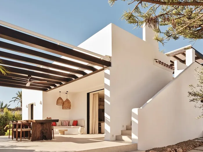 Witte villa met pergola en een terras met zithoek